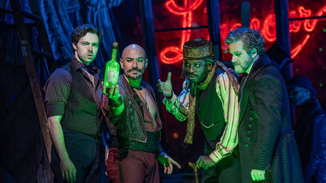 Actors performing a scene in Moulin Rouge! The Musical with a glowing green bottle.