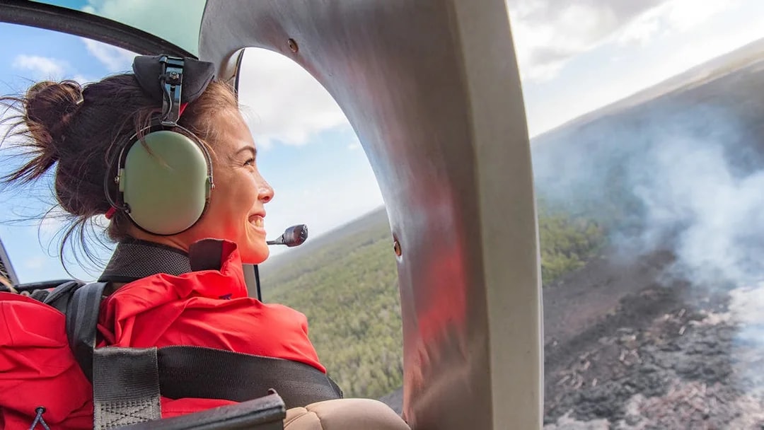 Young tourist in helicopter viewing Mount Etna landscape.