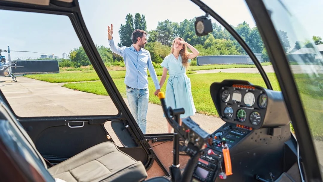 Couple walking towards helicopter on a sunny day.