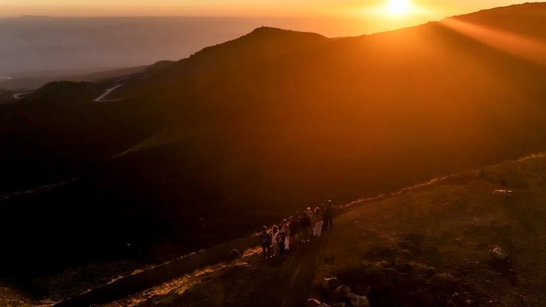 Group of people watching sunset on Mount Etna, Sicily.