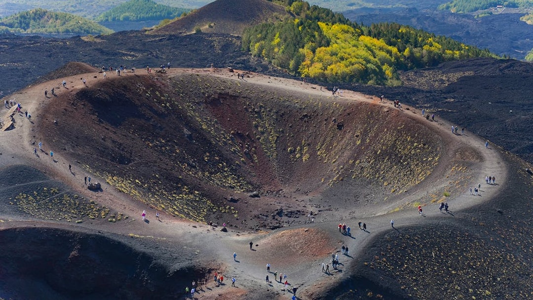 Hikers exploring the rim of Mount Etna Crater in Sicily, Italy.