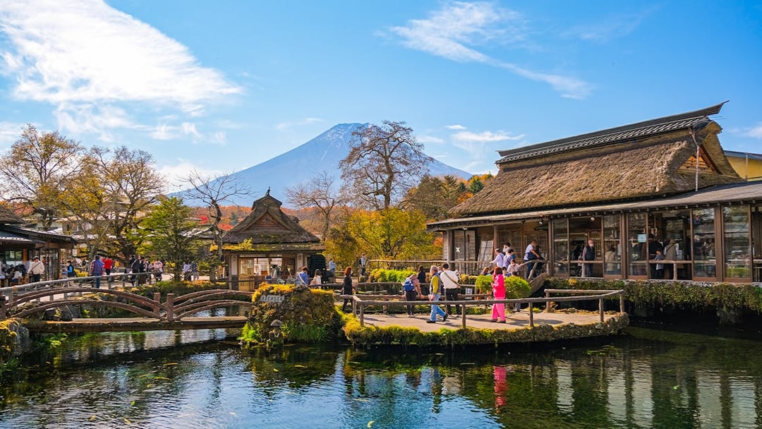 Visitors at Oshino Hakkai ponds with Mount Fuji in the background, Japan.