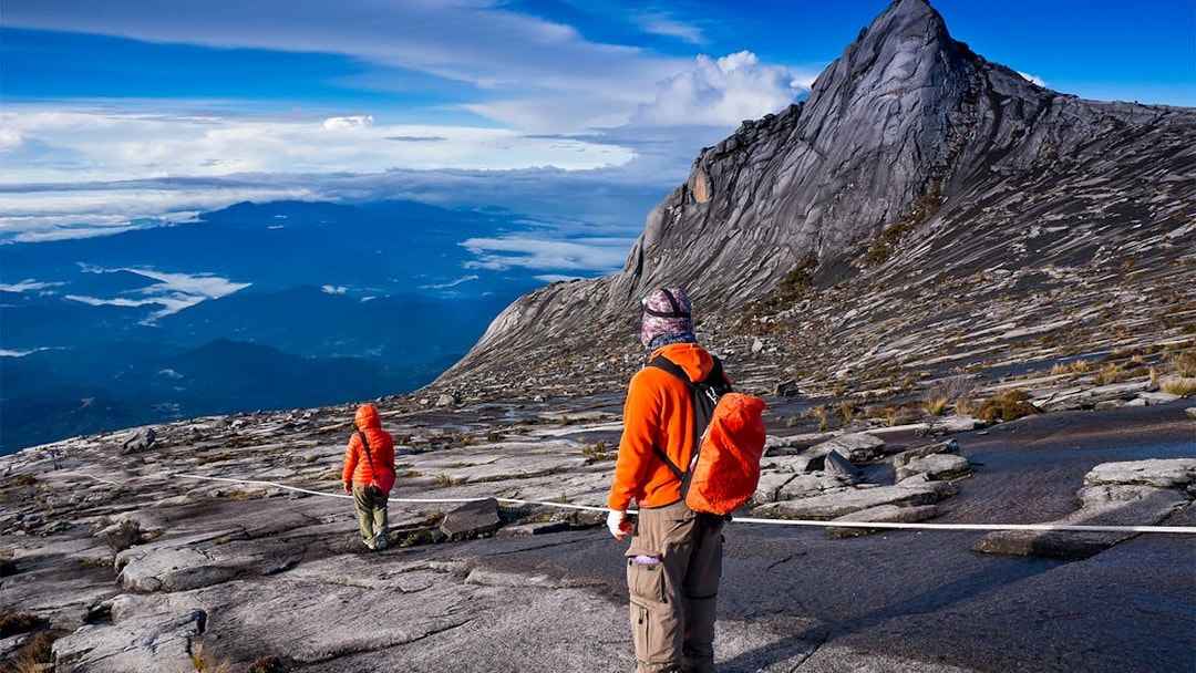 Hikers ascending rocky path on Mount Kinabalu Summit Tour, Malaysia.