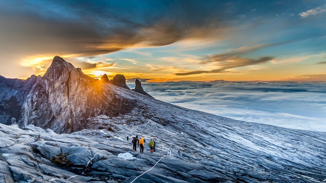 Hikers ascending Mount Kinabalu summit at sunrise, Malaysia.