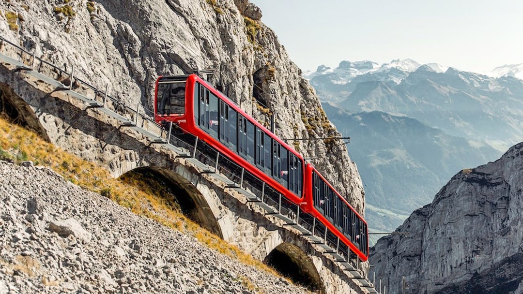 Red train ascending Mount Pilatus on the Pilatusbahn railway, Switzerland.