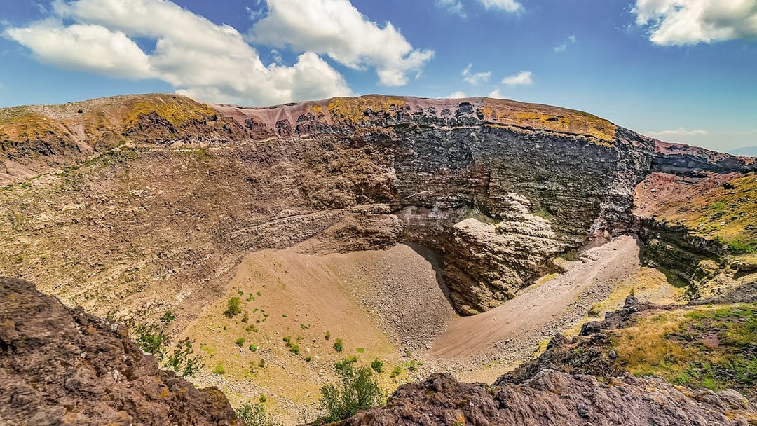 Mount Vesuvius crater with rocky terrain and clear sky in Naples, Italy.