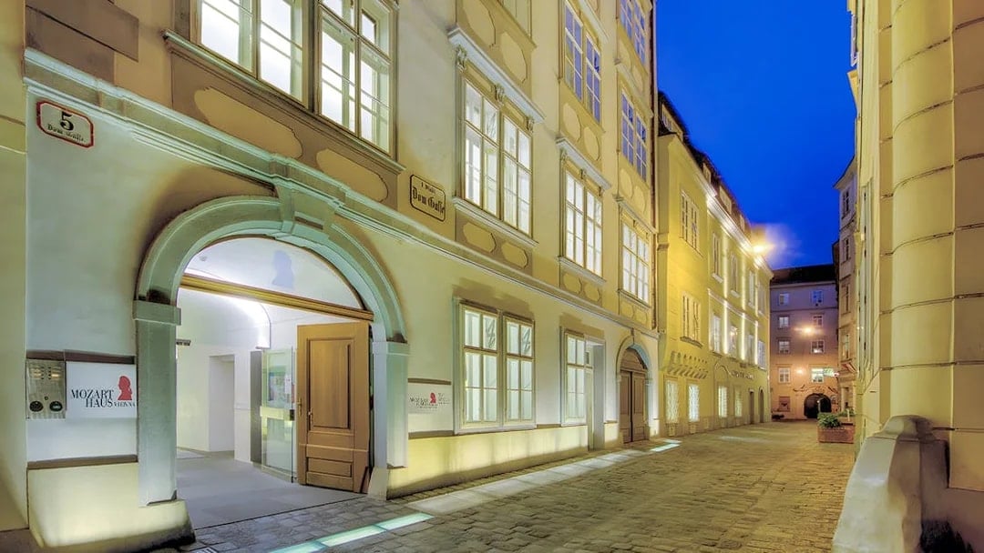 Mozarthaus Vienna entrance at night with open door and illuminated facade.