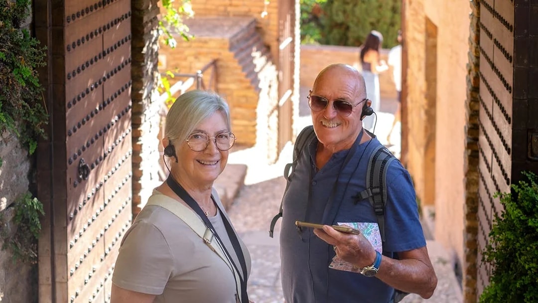 Visitors using audio guides at Montserrat Monastery entrance.