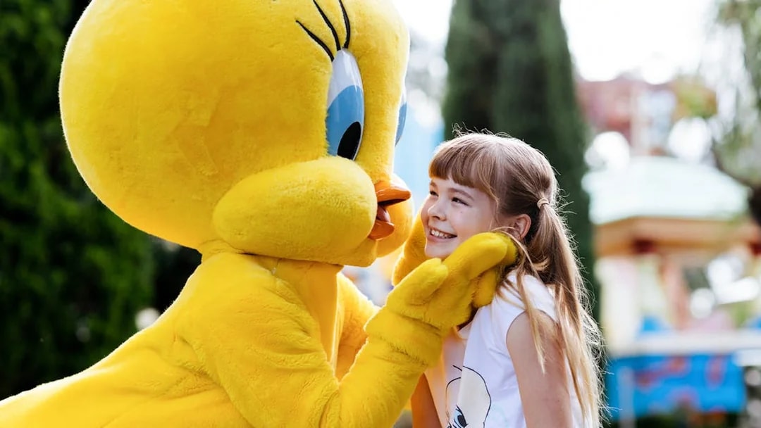 Tweety character greeting a smiling child at a meet and greet event.