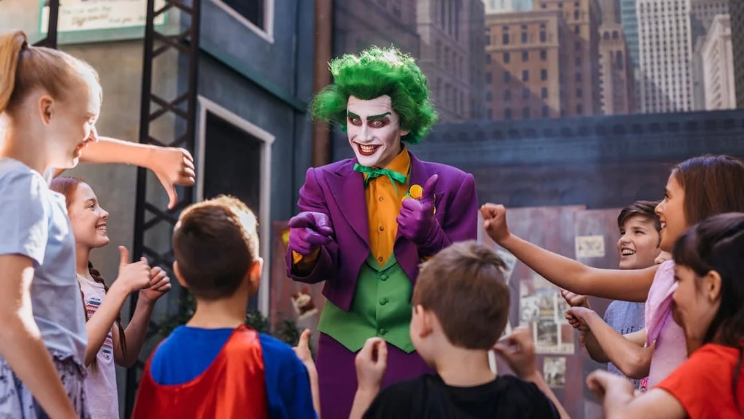 Tourists interact with Joker character at Movie World theme park.