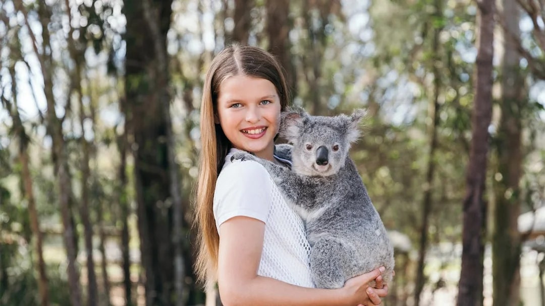 Child holding a koala at Paradise Country, Australia.