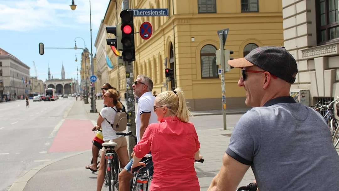 Cyclists on a Munich bike tour pause at a traffic light near Theresienstrasse.