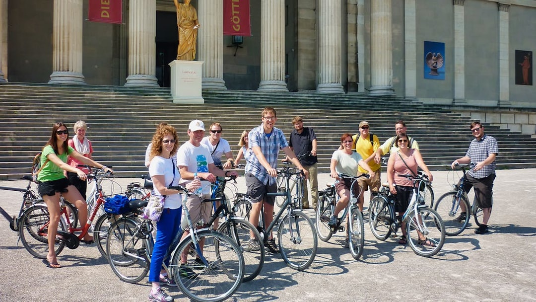Group of cyclists in front of a historic building during a Munich bike tour.