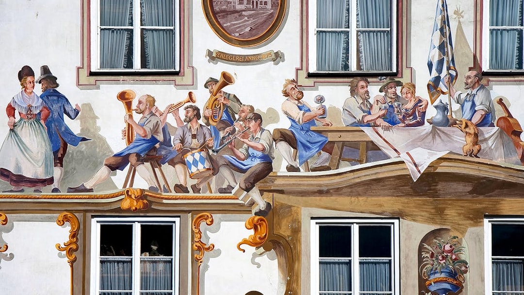 Bavarian mural depicting musicians and dancers on a building facade in Bavaria, Germany.
