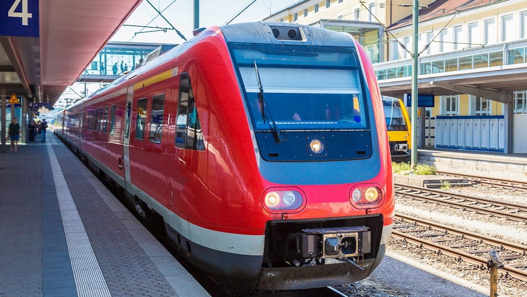 Red train at Munich station for Neuschwanstein Castle tour transfer.