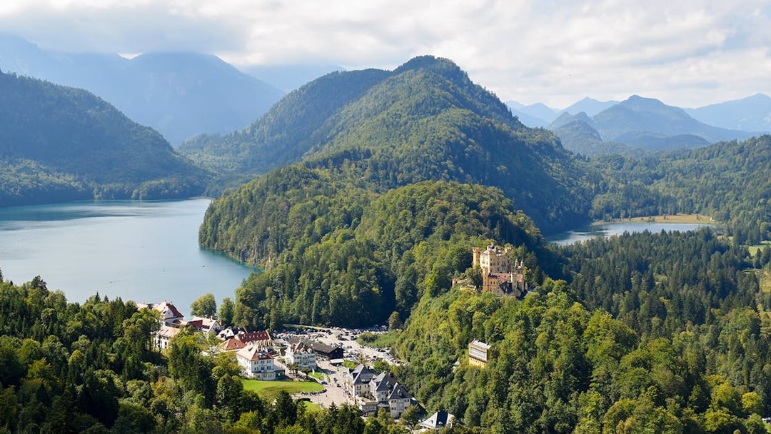 Panoramic view from Neuschwanstein Castle overlooking Bavarian mountains and lakes.