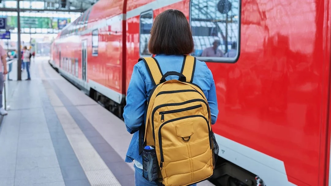 Traveler with backpack at Munich train station for Neuschwanstein Castle tour.