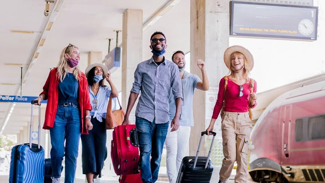 Travelers with luggage at Munich train station for Neuschwanstein Castle tour.