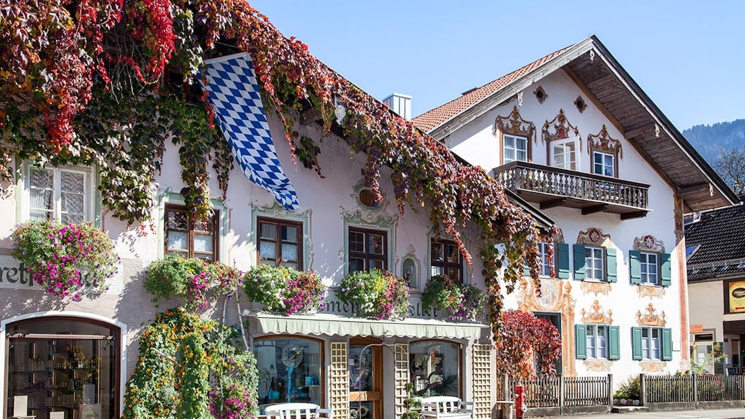 Bavarian house with painted facade and flowers in Oberammergau, Germany.