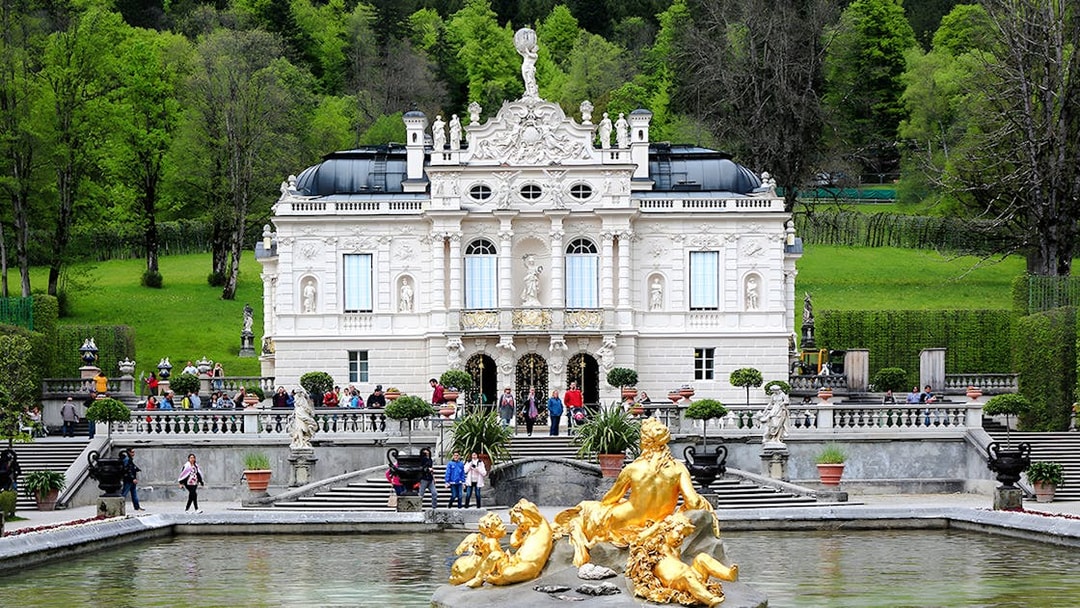 Linderhof Palace exterior with golden fountain statues in Bavaria, Germany.