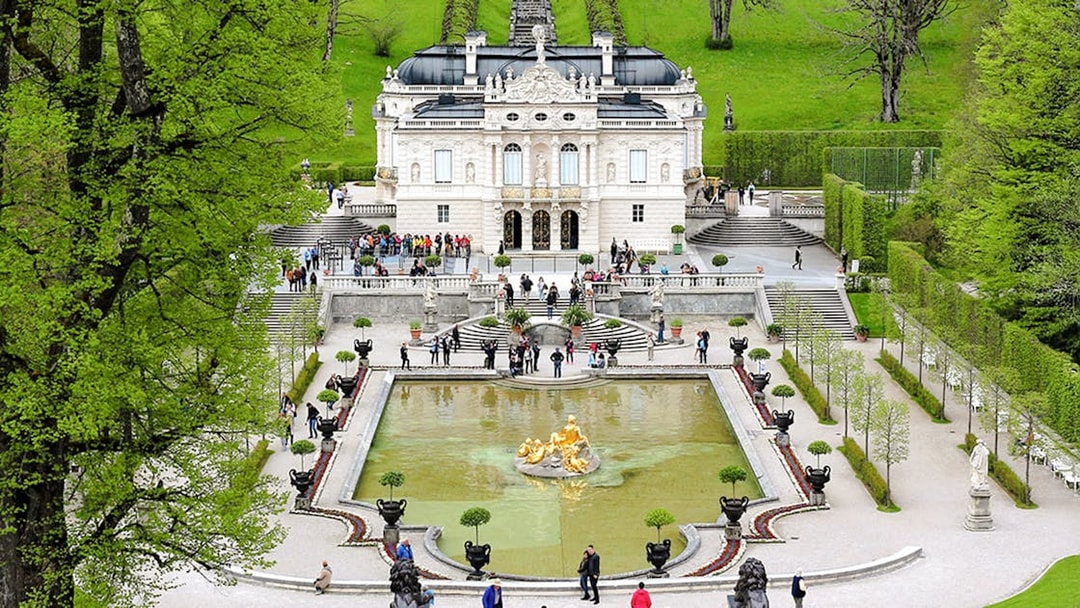 Linderhof Palace gardens with fountain and visitors in Bavaria, Germany.