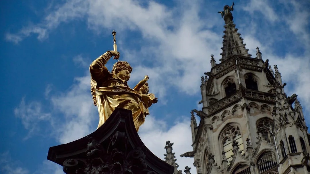 Golden statue and church spire in Munich on Neuschwanstein, Oberammergau & Linderhof tour.