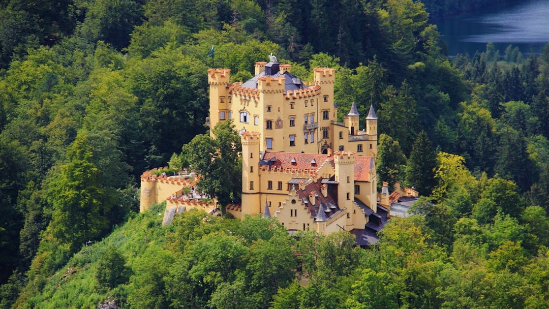 Hohenschwangau Castle surrounded by lush forest, part of the Neuschwanstein and Linderhof excursion.