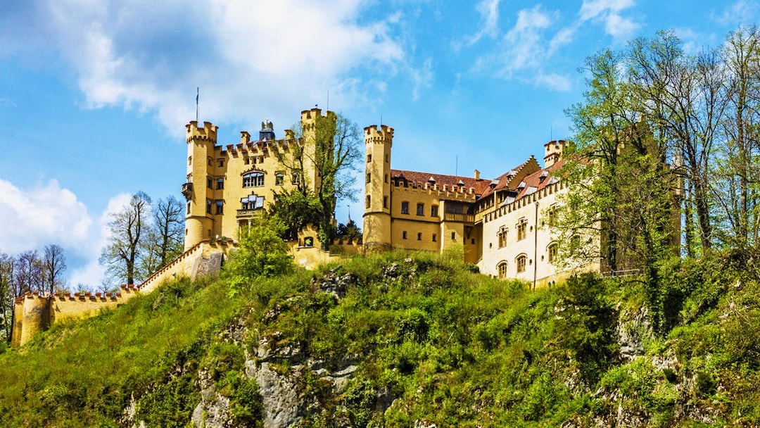 Hohenschwangau Castle on a hill surrounded by trees, Bavaria, Germany.