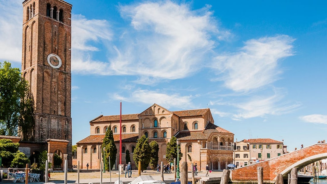 Santi Maria e Donato Basilica with bell tower in Murano, Italy, viewed from canal.