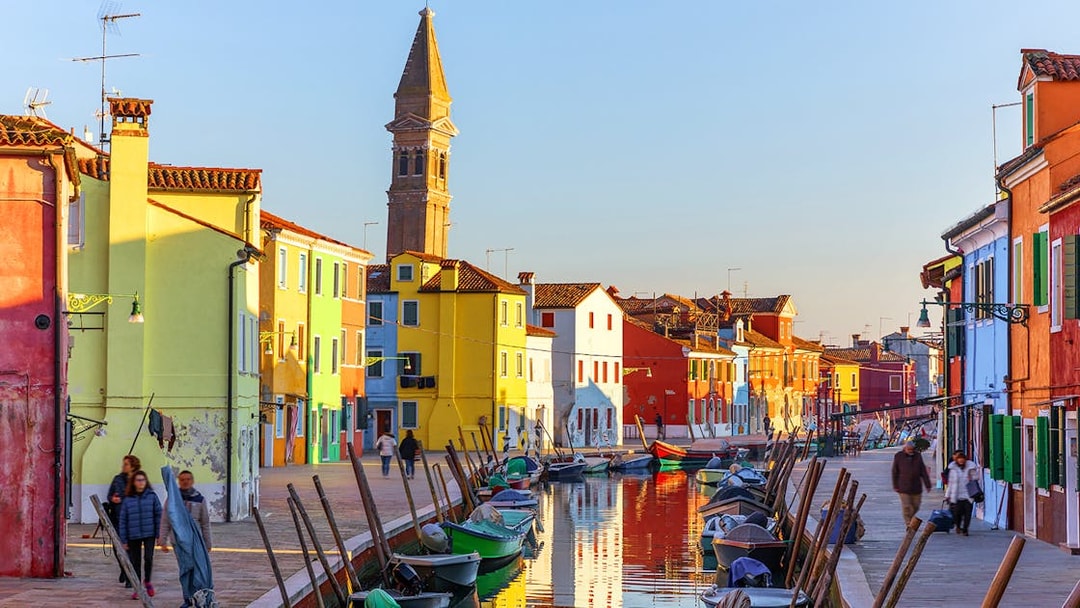 Colorful houses and canal with boats on Burano Island, Italy.