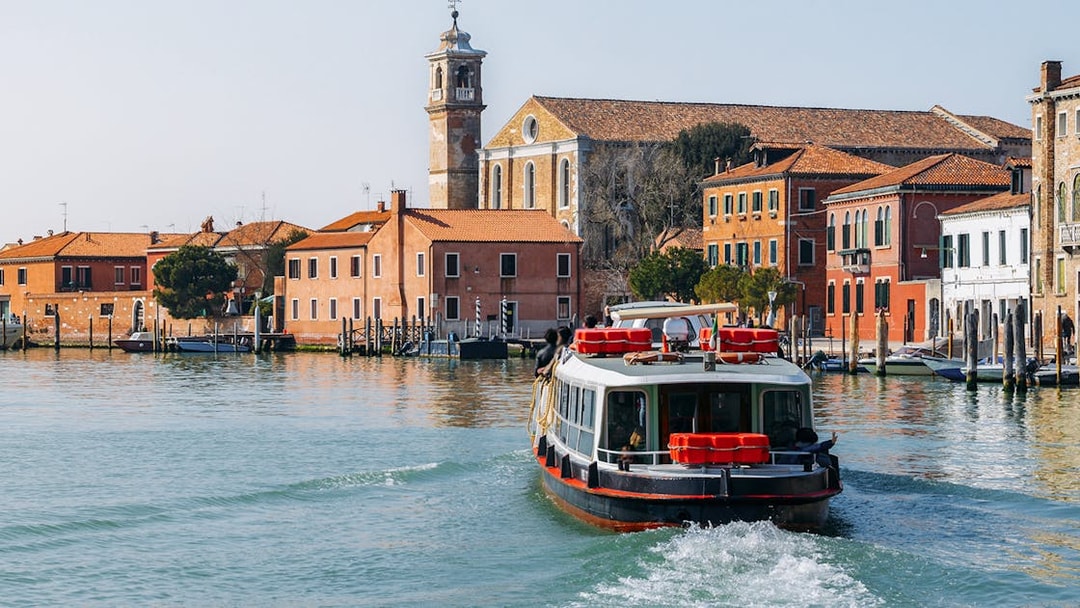 Venice ACTV water bus navigating canal with historic buildings in background.