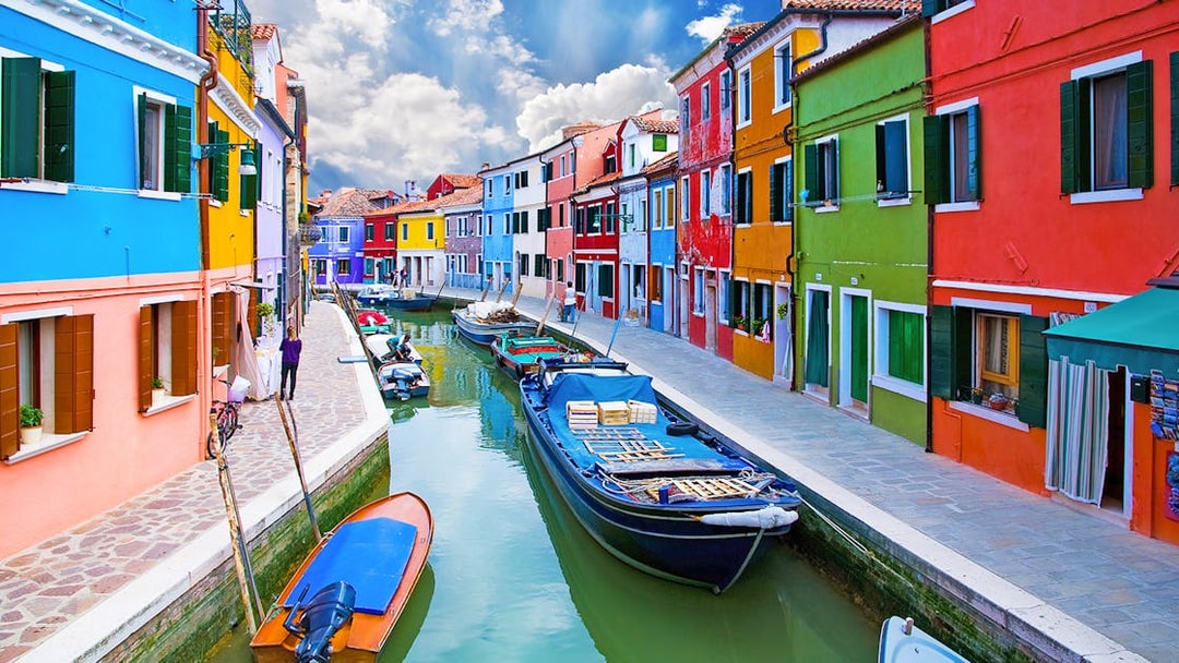 Colorful houses along a canal in Burano, Venice, Italy.