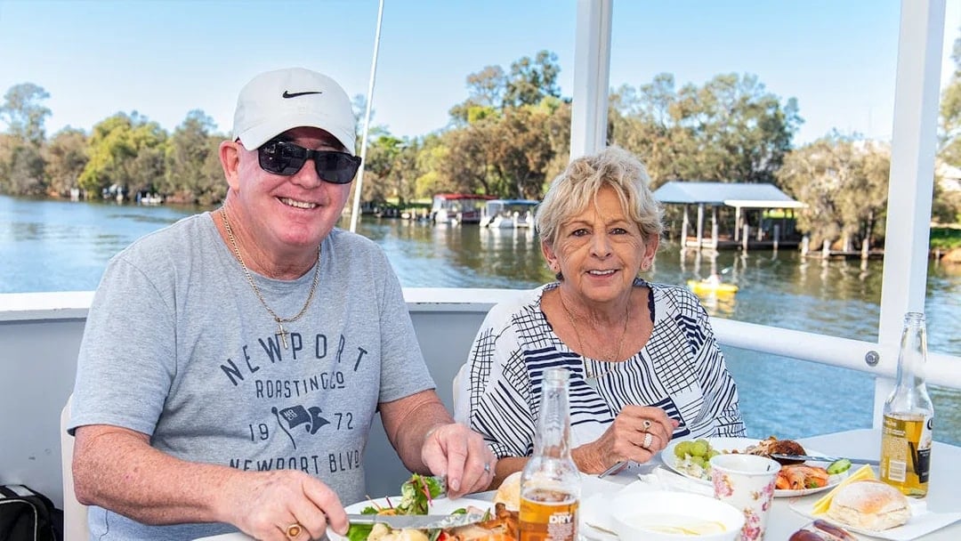 Couple enjoying lunch on a Murray River cruise with scenic river views.