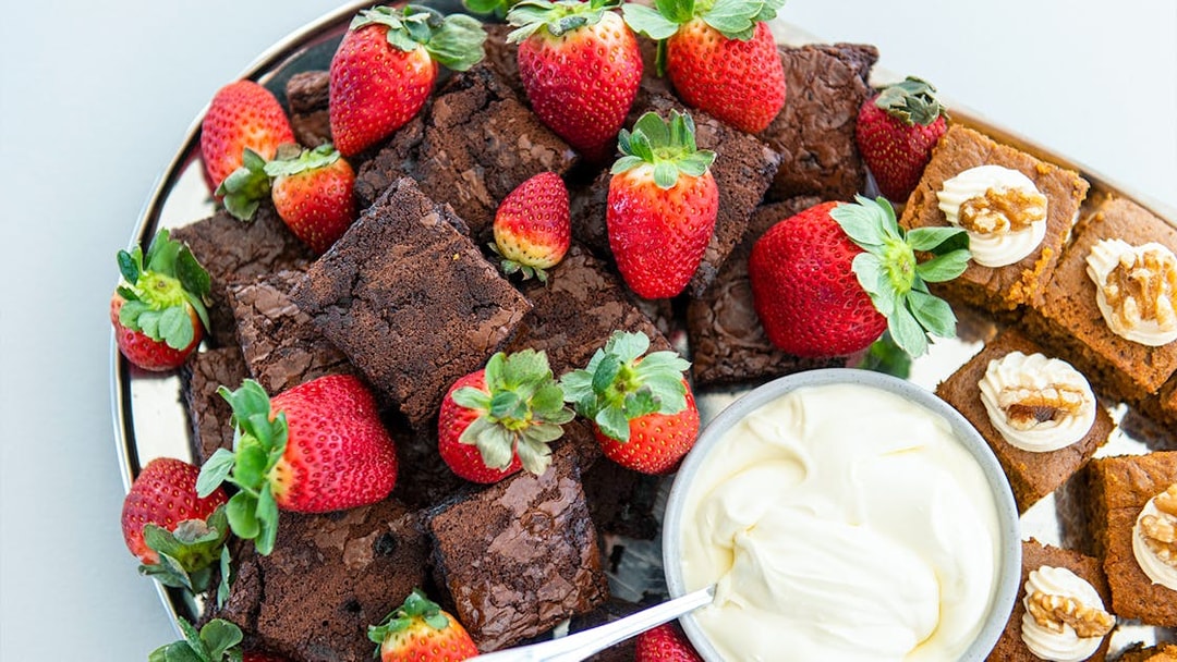 Brownies and strawberries with cream on a platter for Murray River Lunch Cruise.