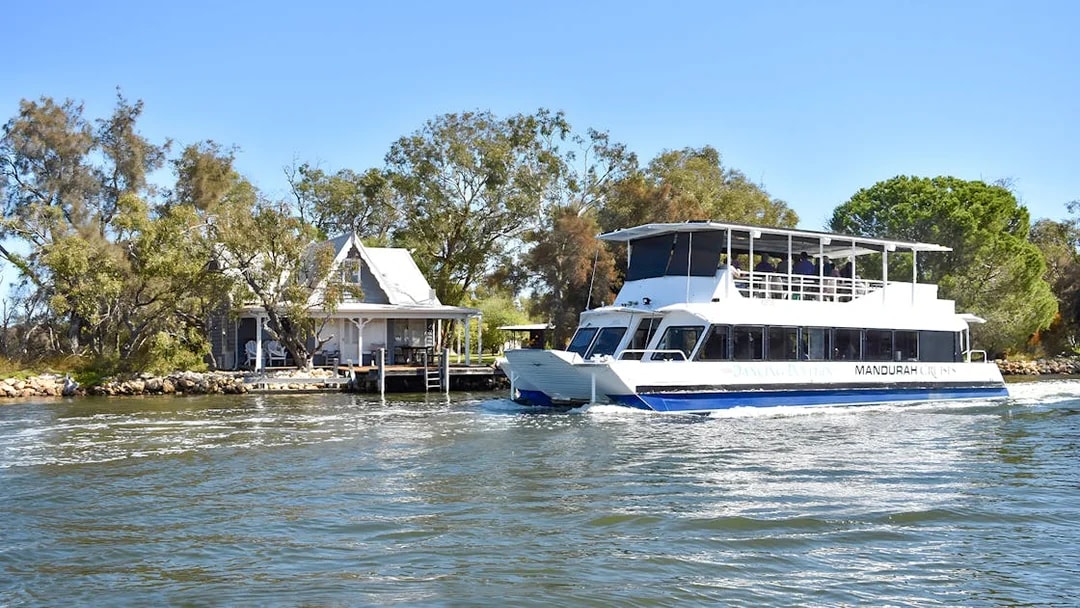 Cruise boat on Murray River passing a riverside house.