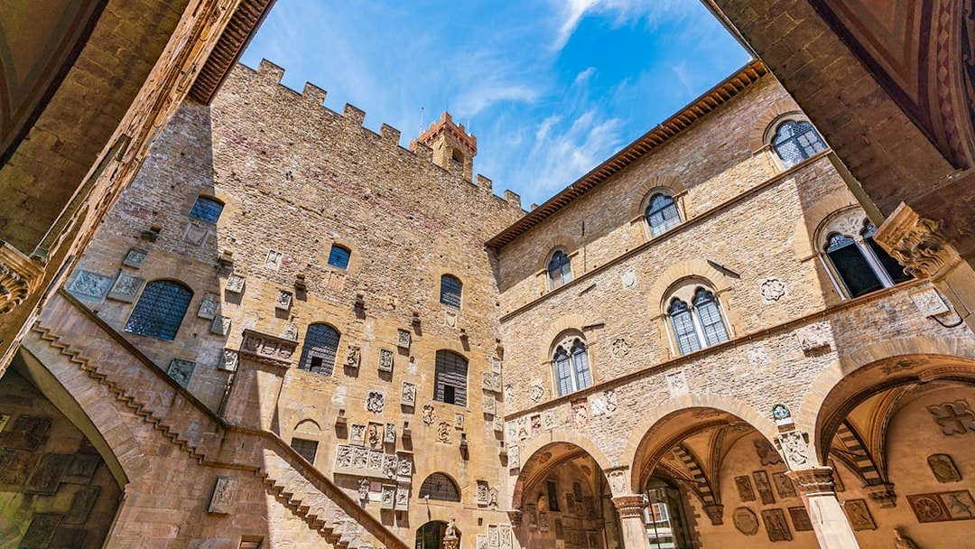 Museo del Bargello courtyard with stone walls and arched windows in Florence, Italy.