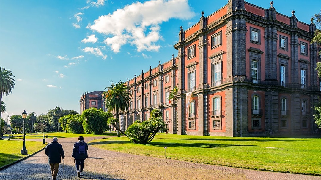 Capodimonte Museum exterior with visitors walking on a sunny day in Naples, Italy.