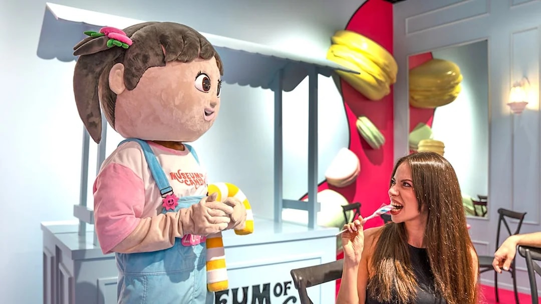 Visitor enjoying candy with cartoon character at Museum of Candy, Dubai.