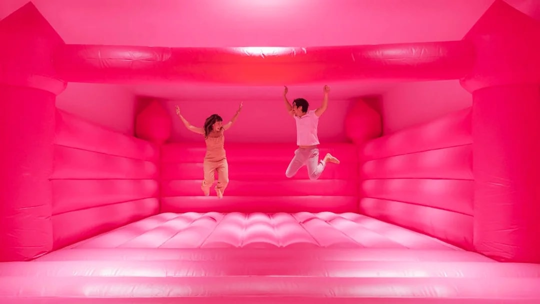Visitors jumping in a pink bounce house at Museum of Ice Cream Singapore exhibit.