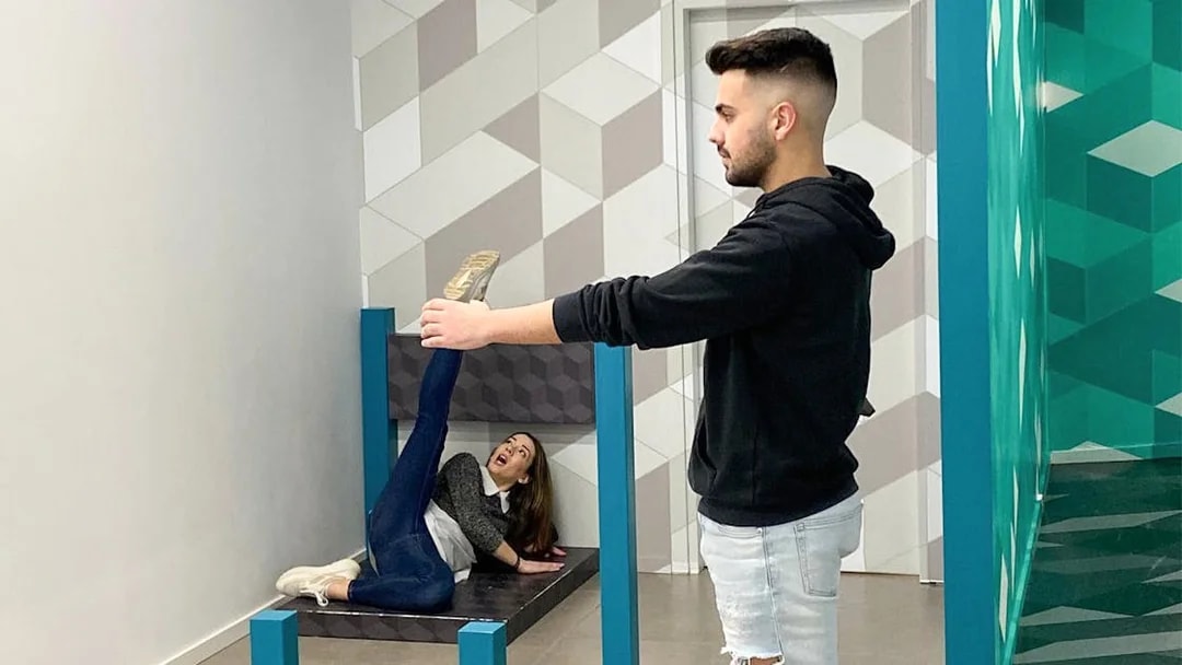 Person interacting with an optical illusion exhibit at the Museum of Illusions.