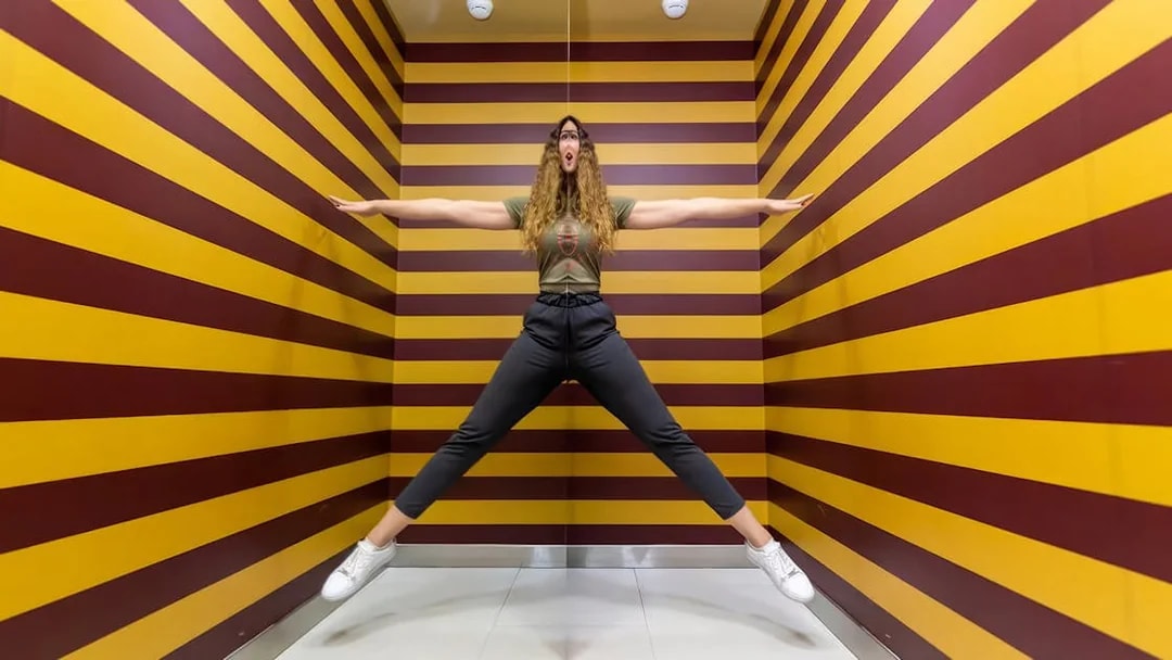 Person posing in an optical illusion room at Museum of Illusions Dubai.