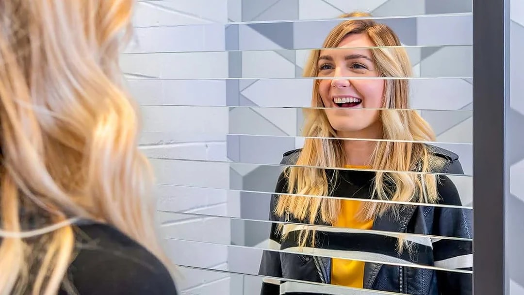 Visitor interacting with mirror illusion at Museum of Illusions Dubai.