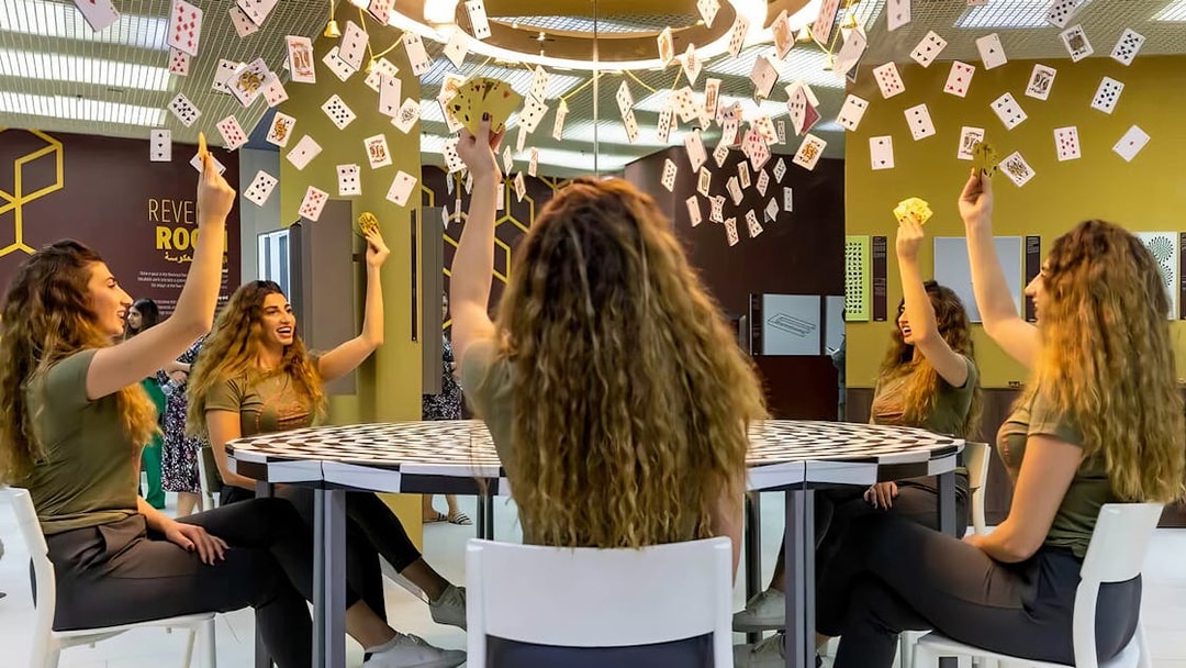 Visitors experiencing optical illusions with mirrors and cards at Museum of Illusions Dubai.