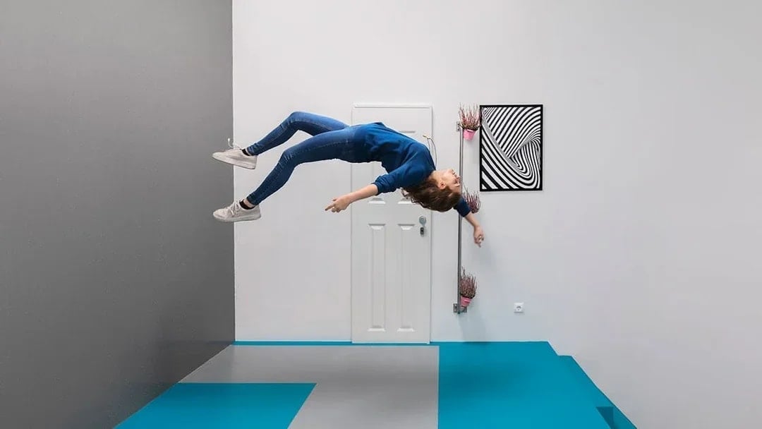 Visitor experiencing gravity-defying illusion at the Museum of Illusions, Vienna.