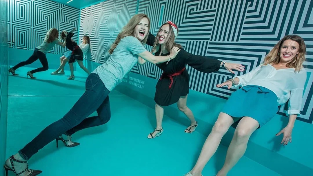 Visitors interacting with optical illusions at Museum of Illusions Vienna.