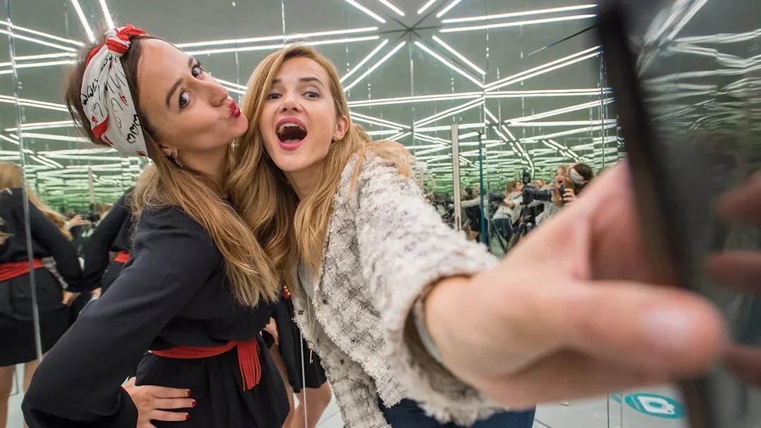Visitors taking a selfie in the mirrored room at the Museum of Illusions, Vienna.