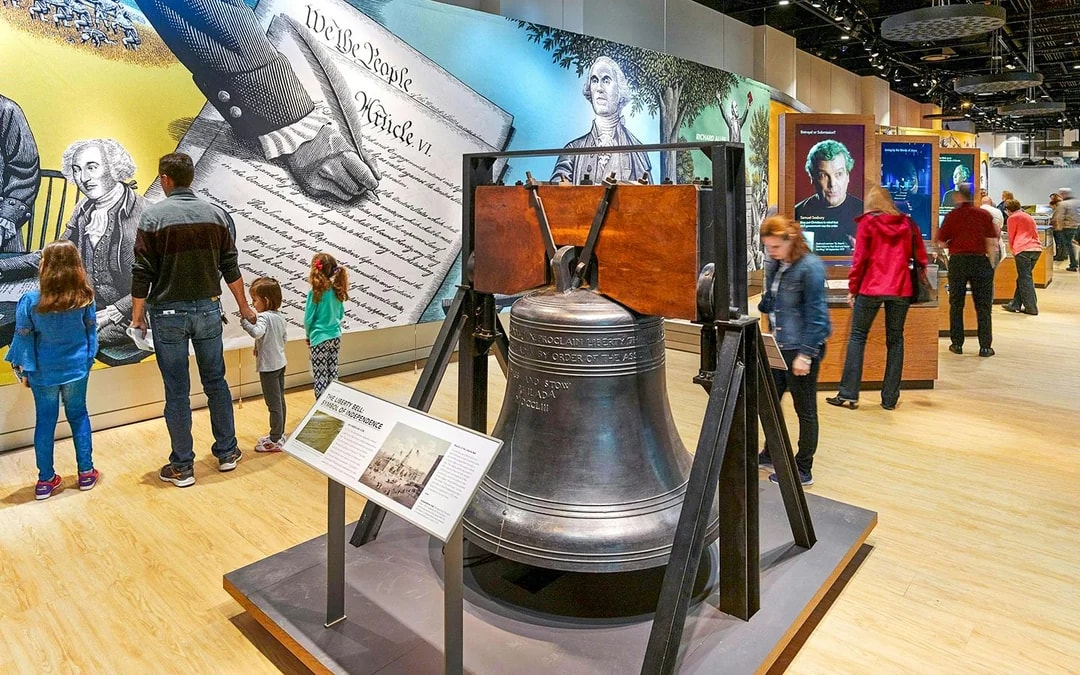 Liberty Bell replica and visitors at Museum of the Bible exhibit.