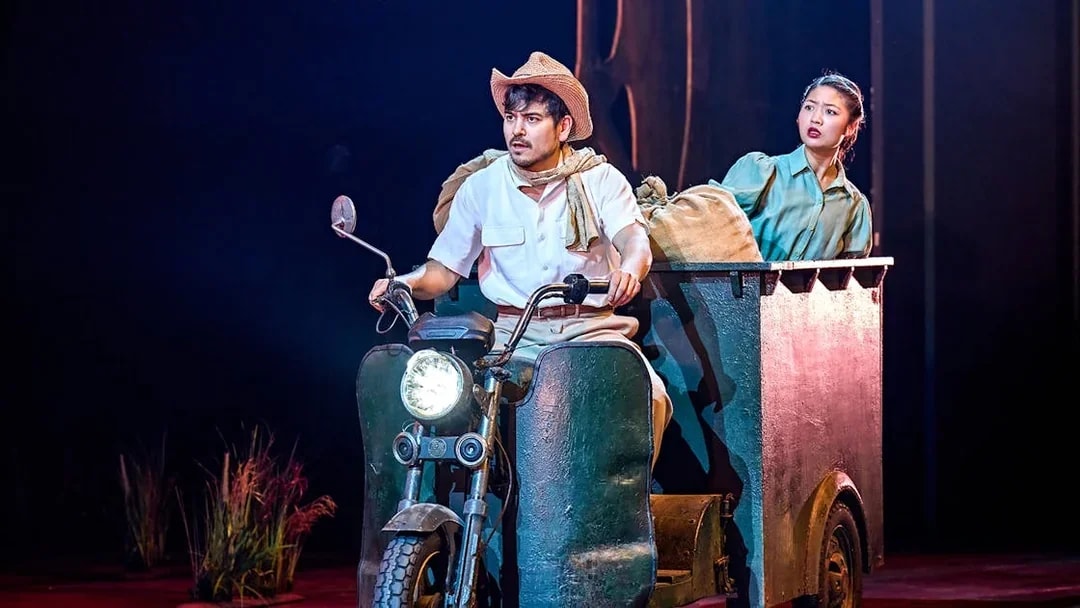 Man and woman on stage in a My Neighbour Totoro performance, riding a motorized cart.