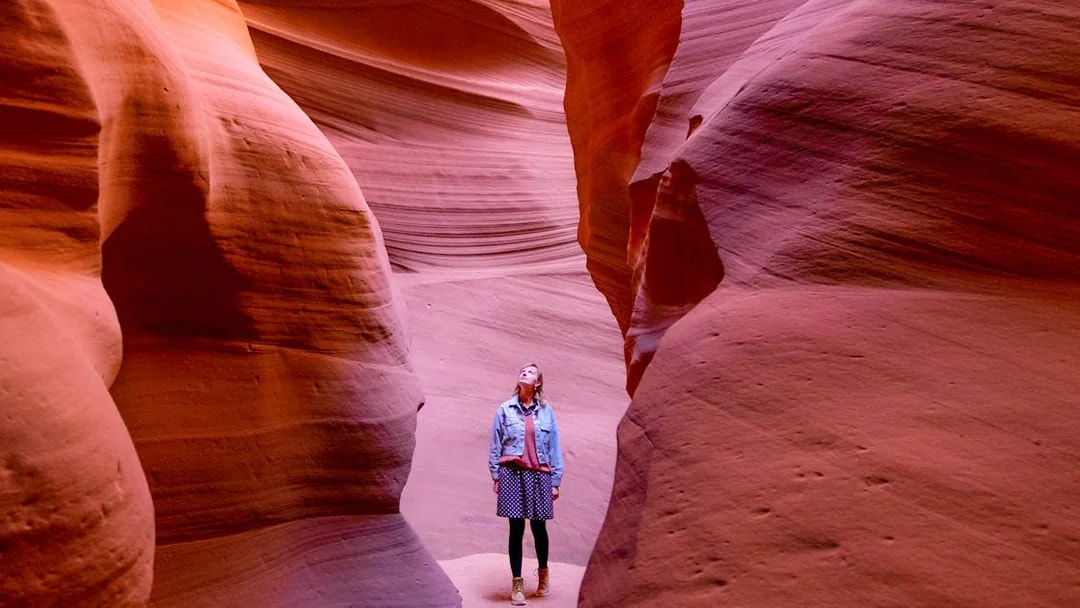 Visitor exploring the narrow sandstone walls of Antelope Canyon.