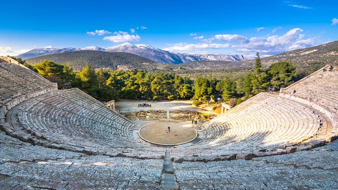 Ancient Epidaurus theater with mountainous backdrop on Nafplio-Mycenae-Epidaurus Day Tour from Athens.